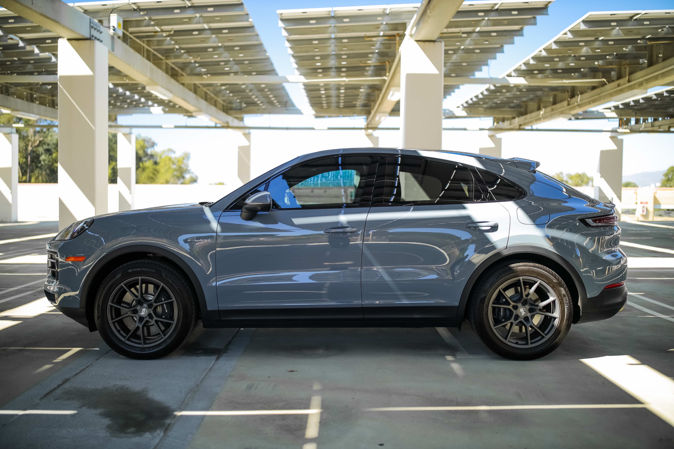 Side profile of the Nardo Grey Porsche Cayenne with e-hybrid badge
