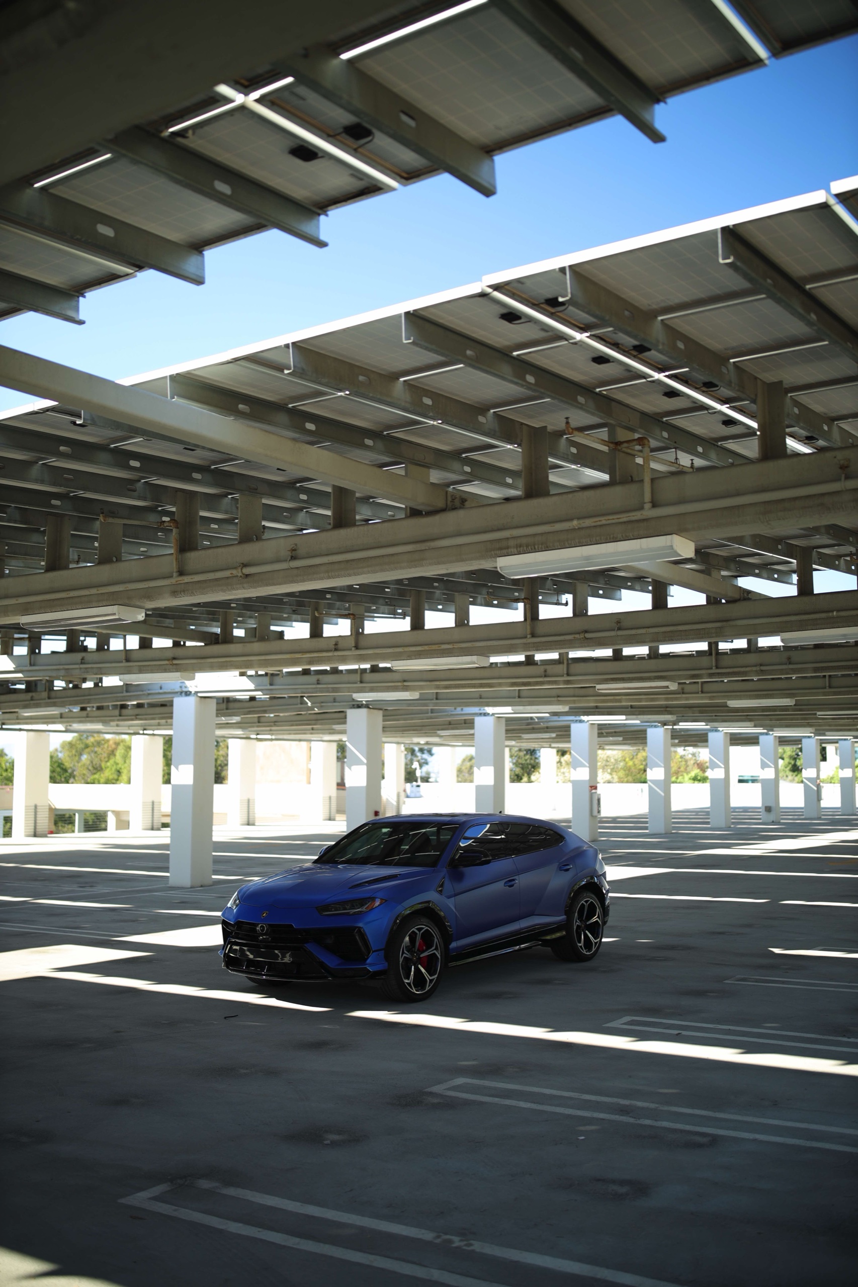 Wide portrait view of the Frozen Blue Lamborghini Urus S under a canopy