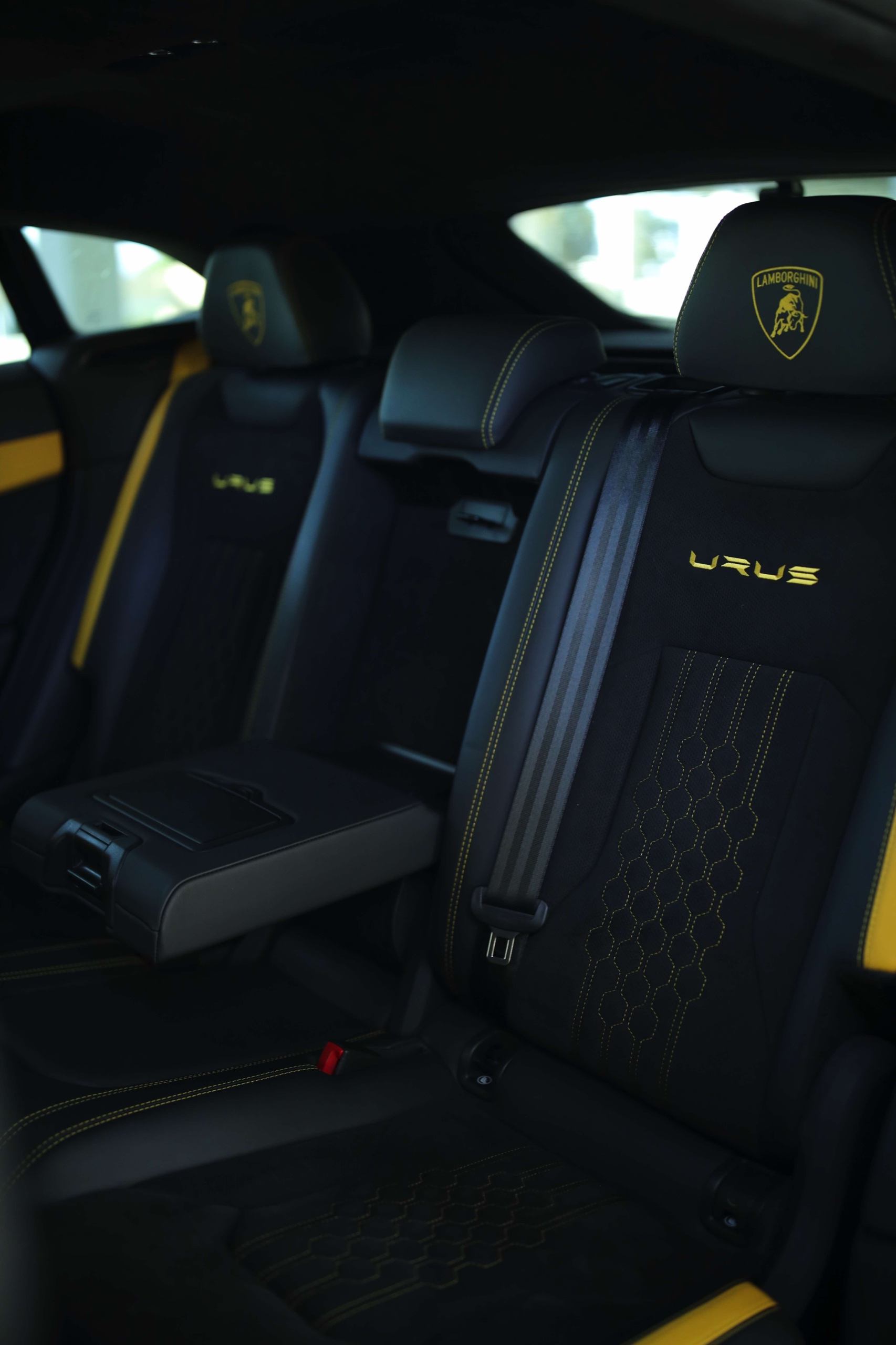Lamborghini Urus S rear seats with yellow stitching and a center armrest